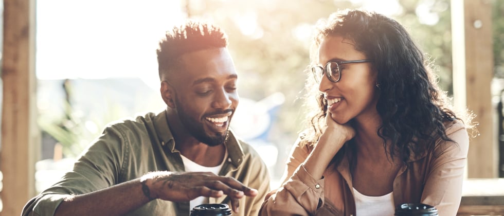 A man and a woman sitting next ot each other mirroring their gestures.