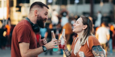 Man and woman outside toasting with drink to symbolise where to meet men